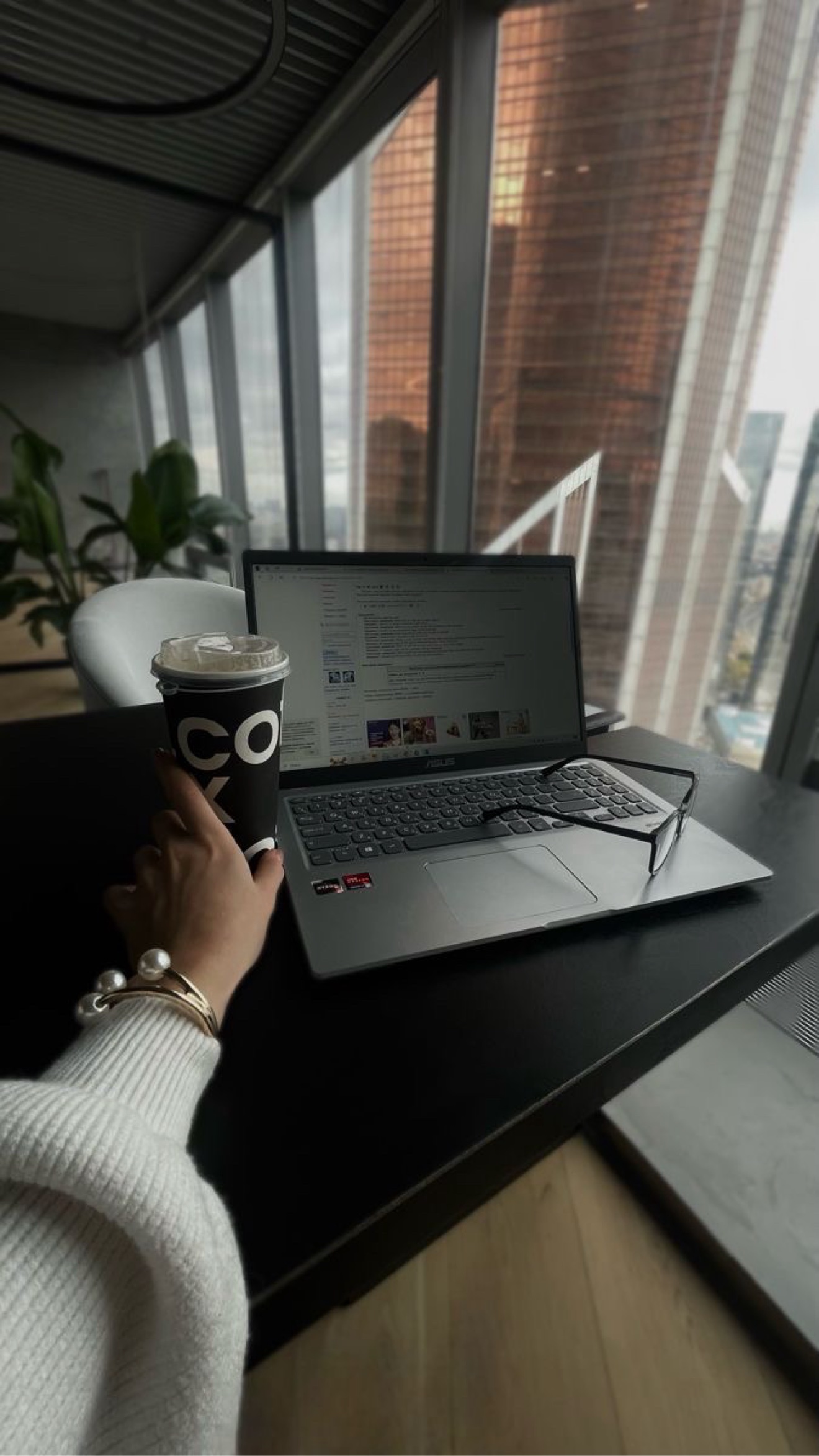Notebook em uma mesa de trabalho diante de uma vista urbana